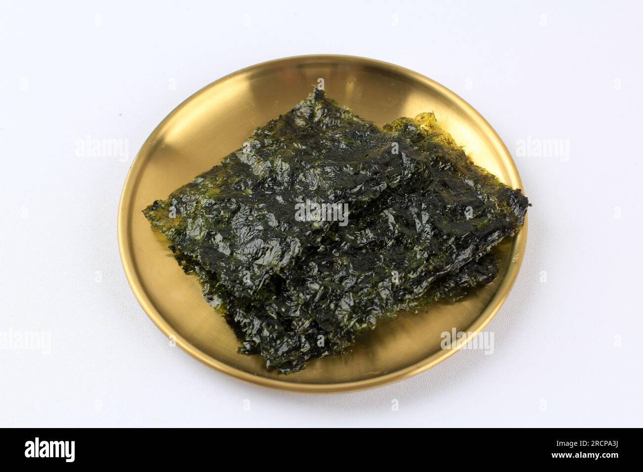 Roasted Nori Laver Seaweed on Golden Plate, Isolated on White Stock