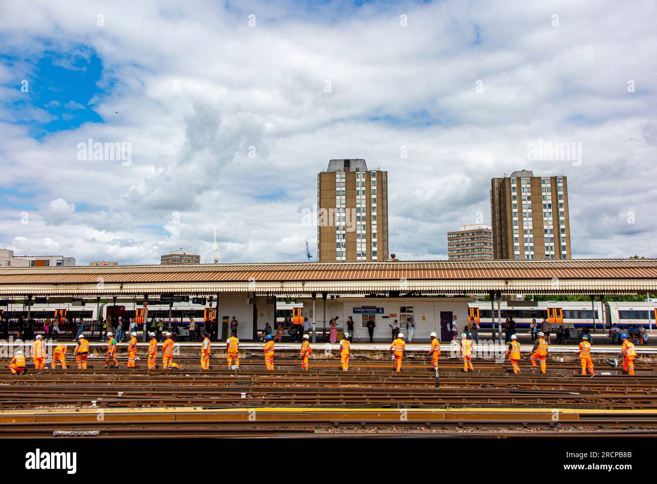 A long line of railway workers pulling a rope at Clapham Junction, London Stock Photo