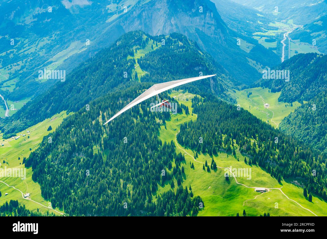 Brave hang glider pilot soar in the mountains in Austrian Alps in Diedams. Extreme sports in European Alps Stock Photo