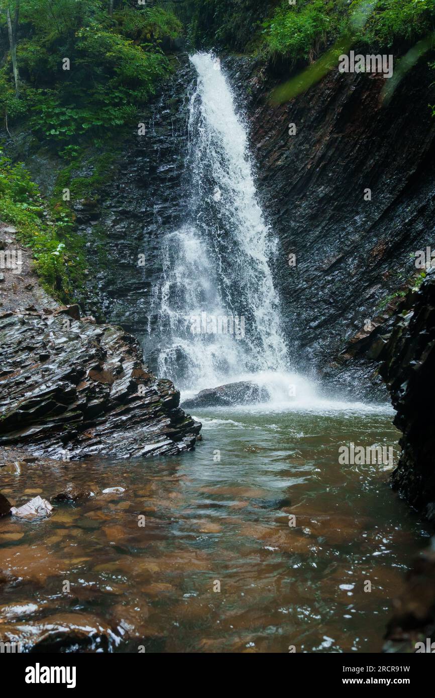 Mountain waterfall, large waterfall water flow, mountain river near the rock. Huk Waterfall, Ukrainian Carpathians Stock Photo