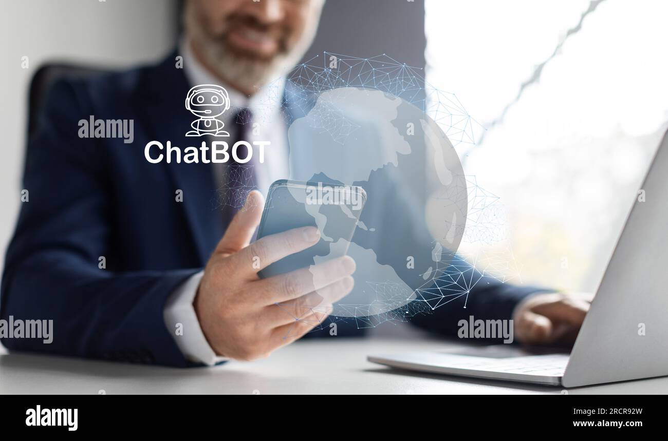 Middle aged businessman wearing working on laptop, smartphone, using chatbot Stock Photo