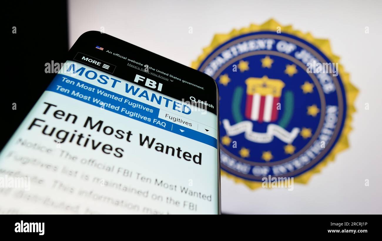 Smartphone with website of US Federal Bureau of Investigation (FBI) on screen in front of seal. Focus on top-left of phone display. Stock Photo