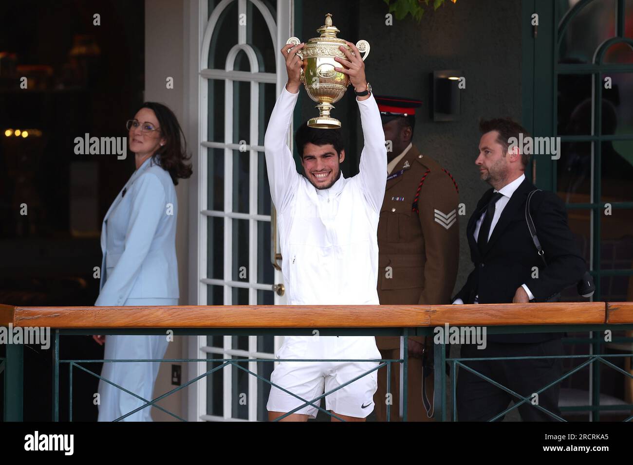 Carlos Alcaraz with the Gentlemen's Singles Trophy on the balcony following his victory over Novak Djokovic on day fourteen of the 2023 Wimbledon Championships at the All England Lawn Tennis and Croquet Club in Wimbledon. Picture date: Sunday July 16, 2023. Stock Photo