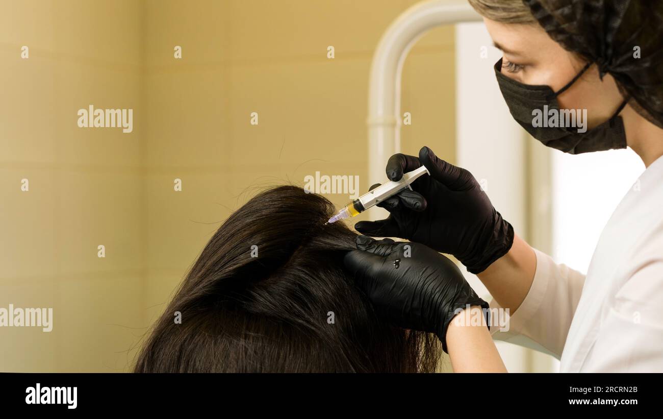 Esthetician uses thin needle to inject PlateletRich Plasma in scalp. Treatment of alopecia with