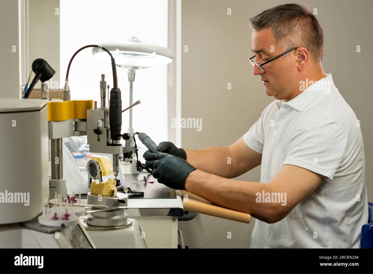 Dental technician specialist working with tooth denture. Dental office