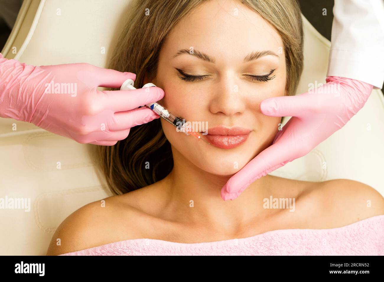 Lip augmentation procedure in beauty clinic. Adjustment shape and