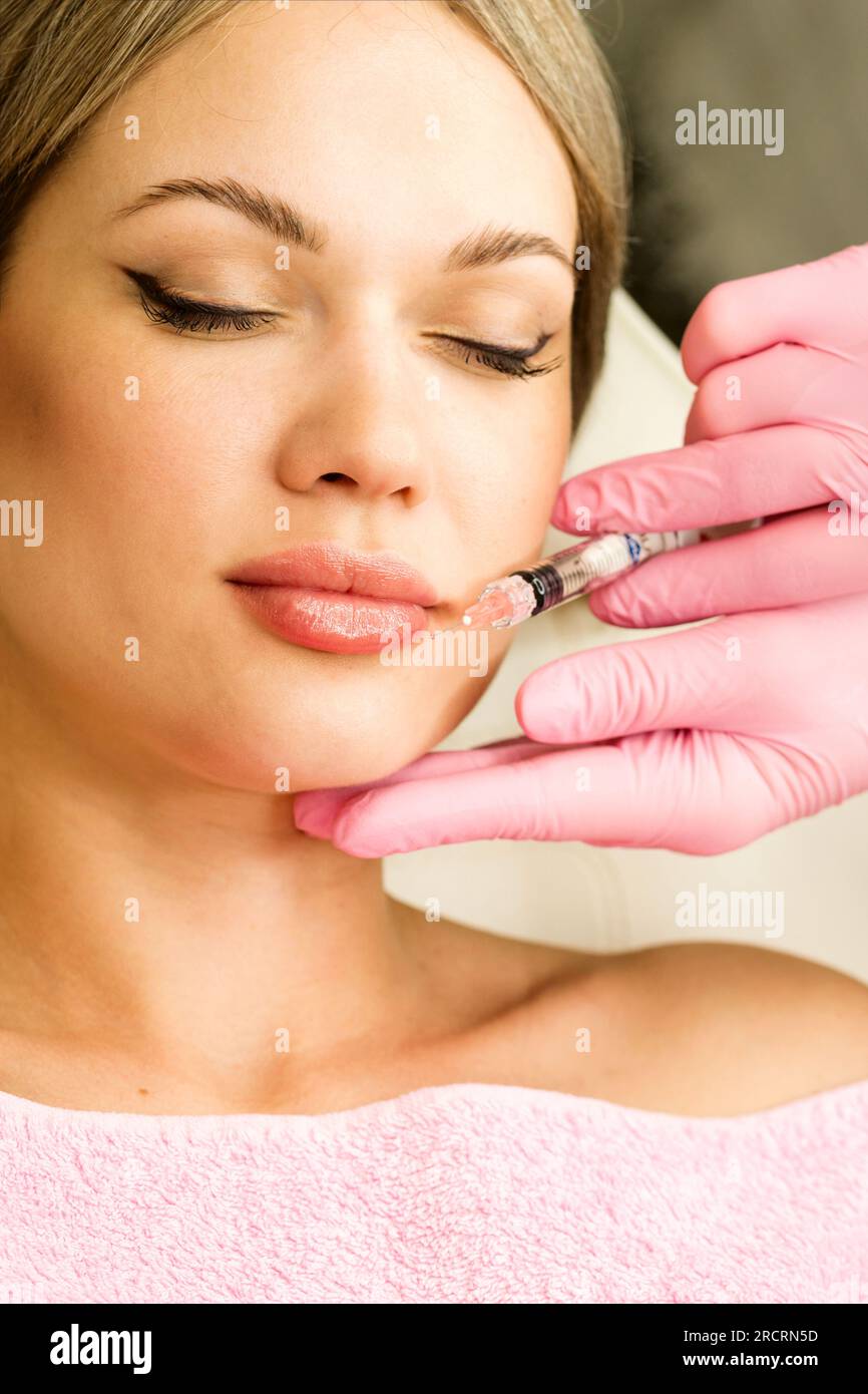 Lip augmentation procedure in beauty clinic. Adjustment shape and volume  lips form female patient. Filler injection for lips augmentation with  hyaluro Stock Photo - Alamy