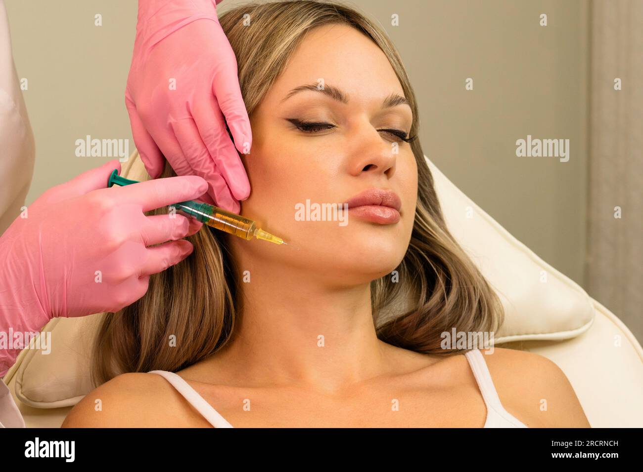 Сosmetologist uses thin needle to inject PlateletRich Plasma in skin