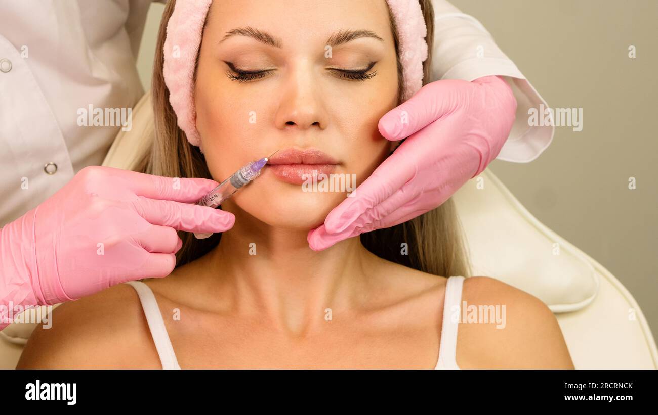 Lip augmentation procedure in beauty clinic. Adjustment shape and
