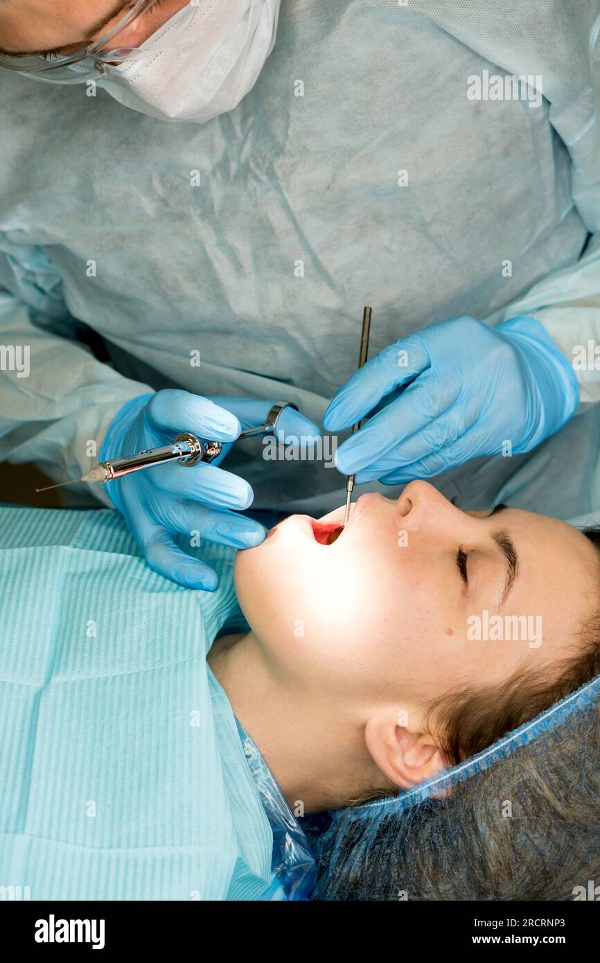 Dental surgeon performs conduction anesthesia with lidocaine using a