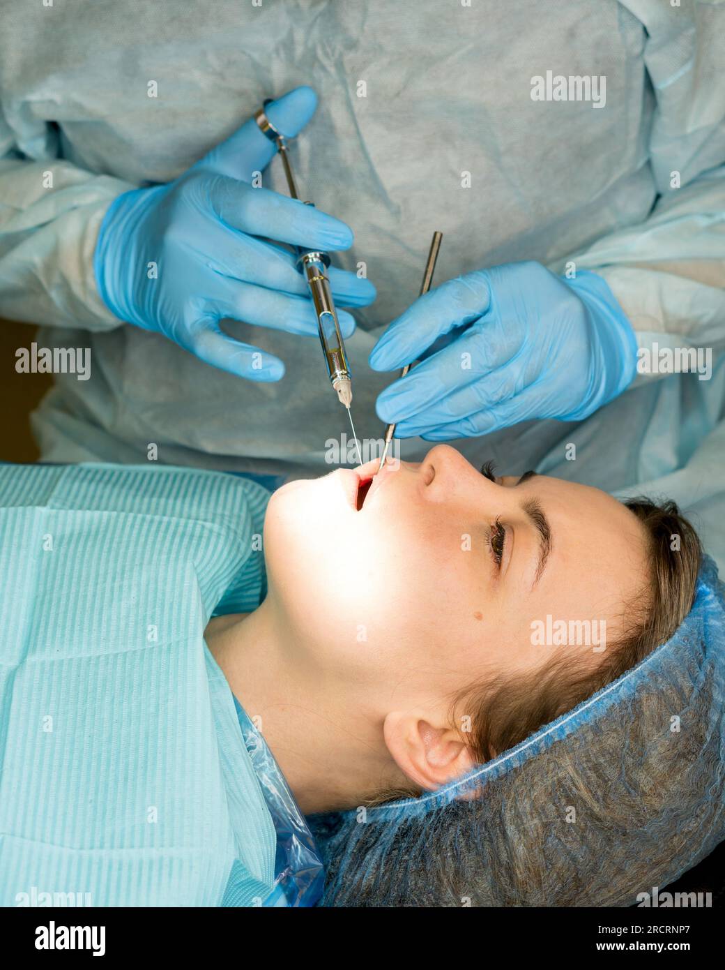 Dental surgeon performs conduction anesthesia with lidocaine using a
