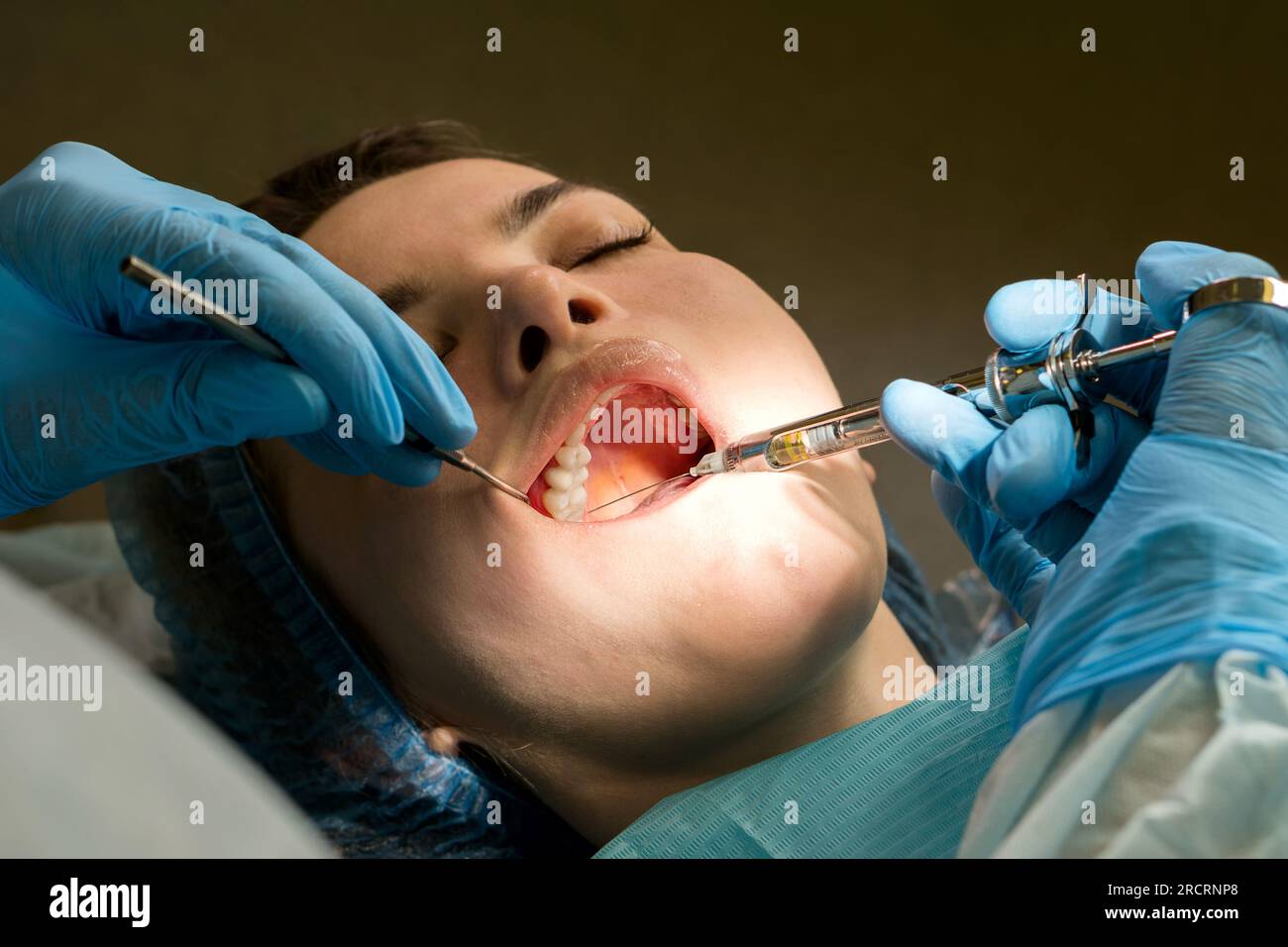 Dental surgeon performs conduction anesthesia with lidocaine using a