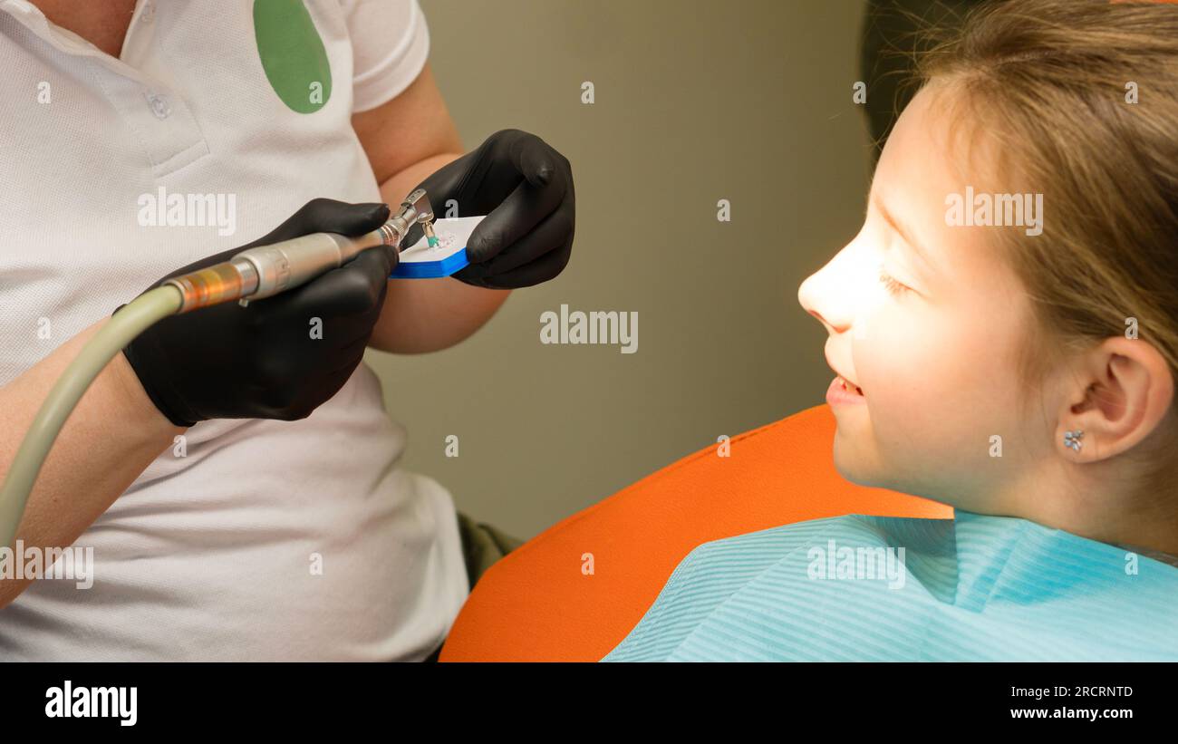 Girl on dental appointment. Professional oral hygiene. Atraumatic