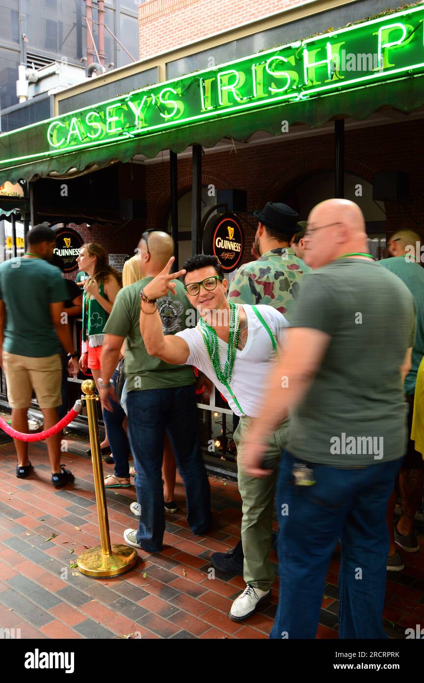 A young man shows his party side at a St Patrick’s Day celebration wearing green and waving in Los Angeles Stock Photo