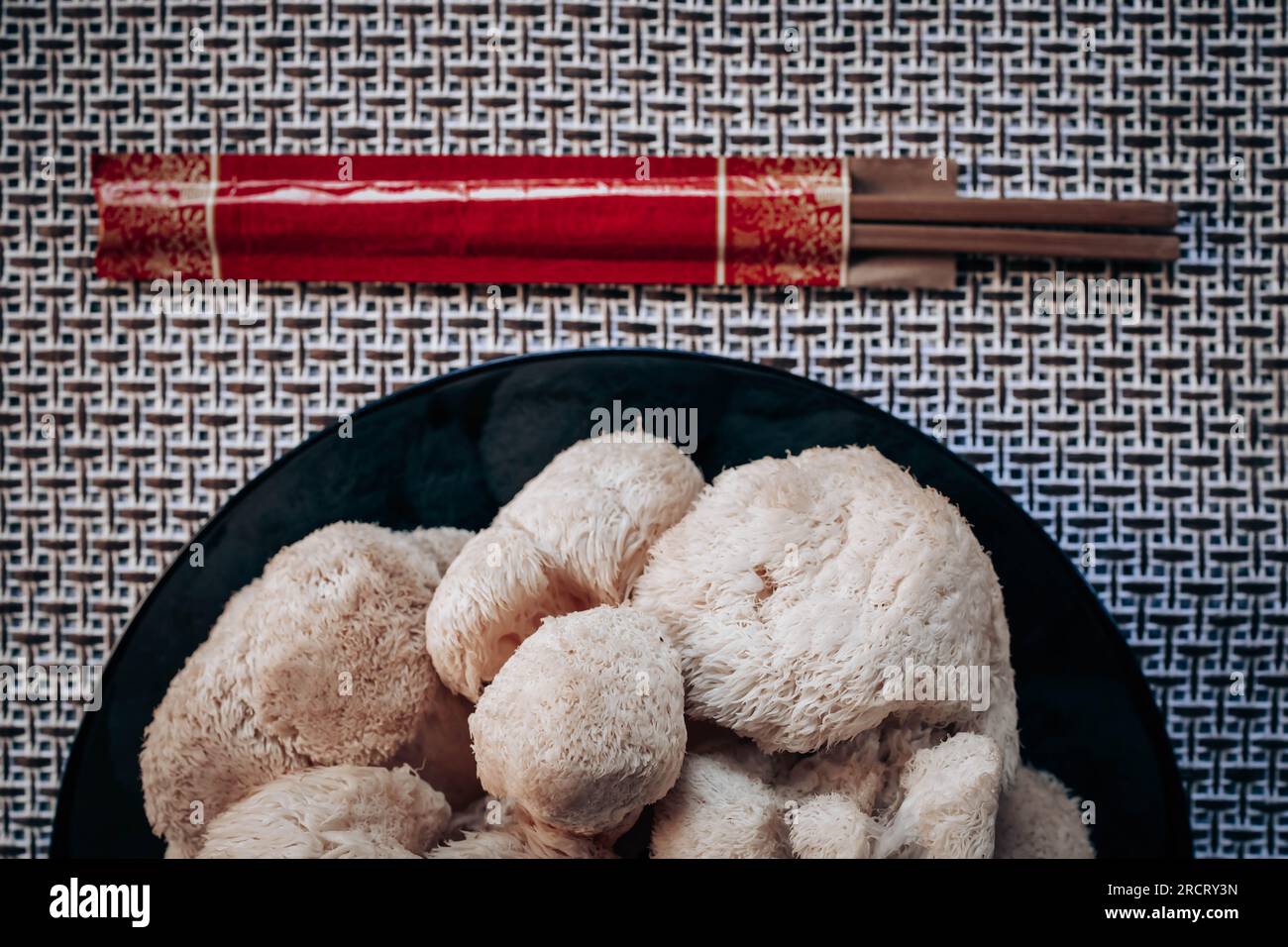 Hericium erinaceus or Lions mane mushroom with a Chinese chopsticks. Medical mushroom concept Stock Photo