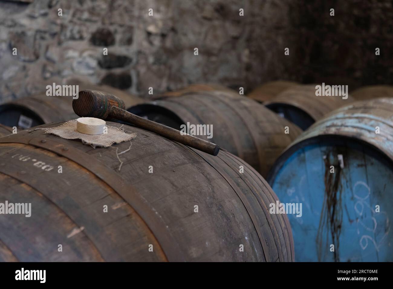 A Wooden Mallet with a Poplar Bung and Hessian Bung Cloth on Top of a Whisky Cask in a Warehouse at Royal Lochnagar Distillery in Aberdeenshire Stock Photo