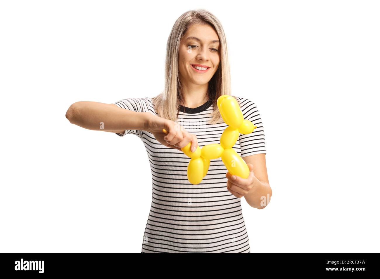 Woman making a dog from a yellow balloon isolated on white background Stock Photo