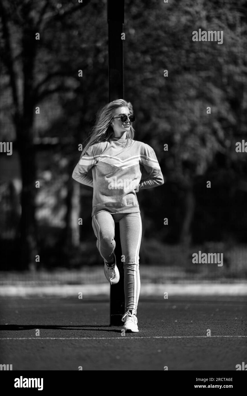sports girl blonde stands on the basketball court black and white Stock