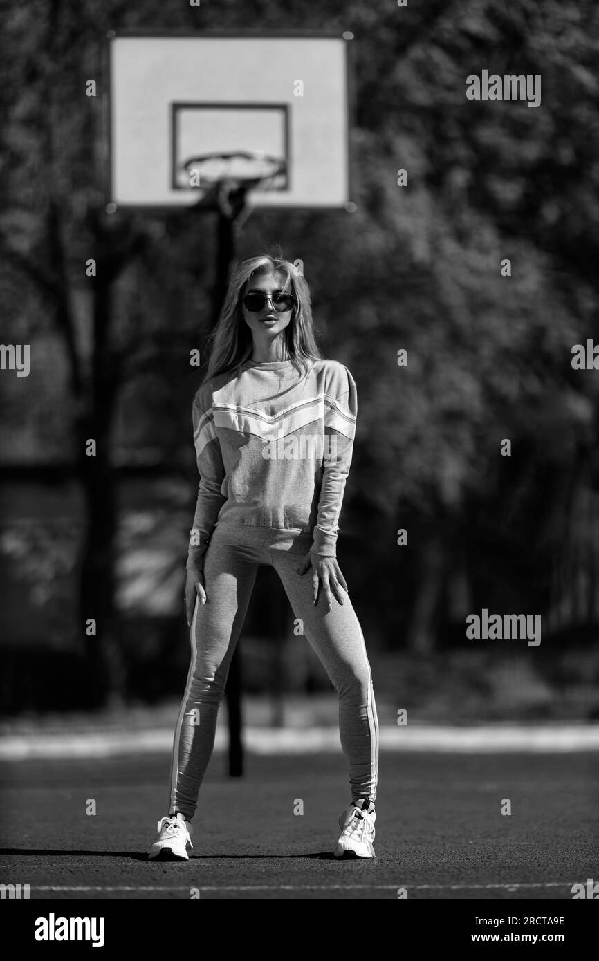 sports girl blonde stands on the basketball court black and white Stock