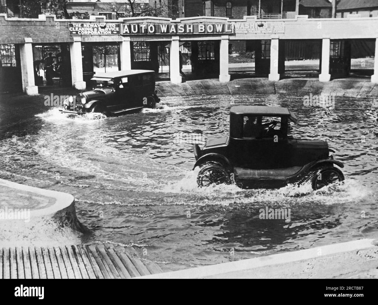 Chicago, Illinois:  September 20, 1924 A new method of washing autos in Chicago. Two cars at a time run through the Auto Wash Bowl to clean the mud and dirt from the wheels and axles. Stock Photo
