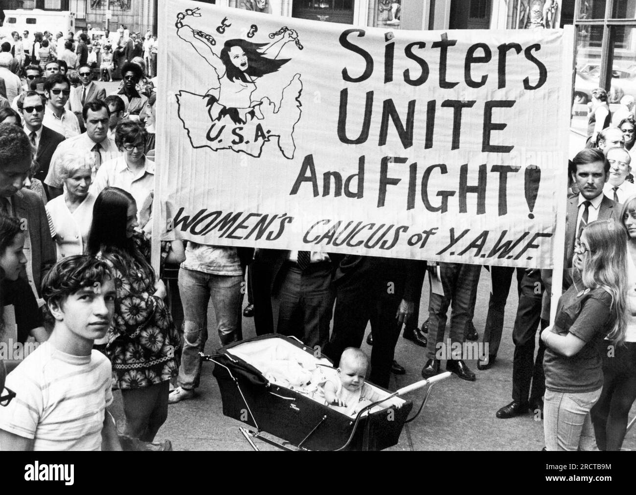 Chicago, Illinois:  August 26, 1970 The Women's Liberation movement mounted its strongest campaign for equal rights to date with over 4,000 persons turning out for the 50th anniversary of women's suffrage. The sign calls for The Women's Caucus of Youth Against War and Facism (YAWF) to unite and fight. Stock Photo