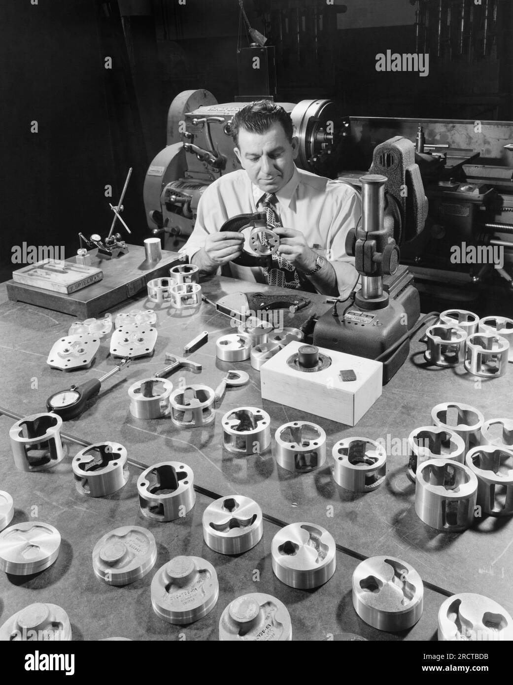United States:   c. 1947 A quality control inspector uses a caliper to check housing parts used in Chevrolet manufacturing. Stock Photo
