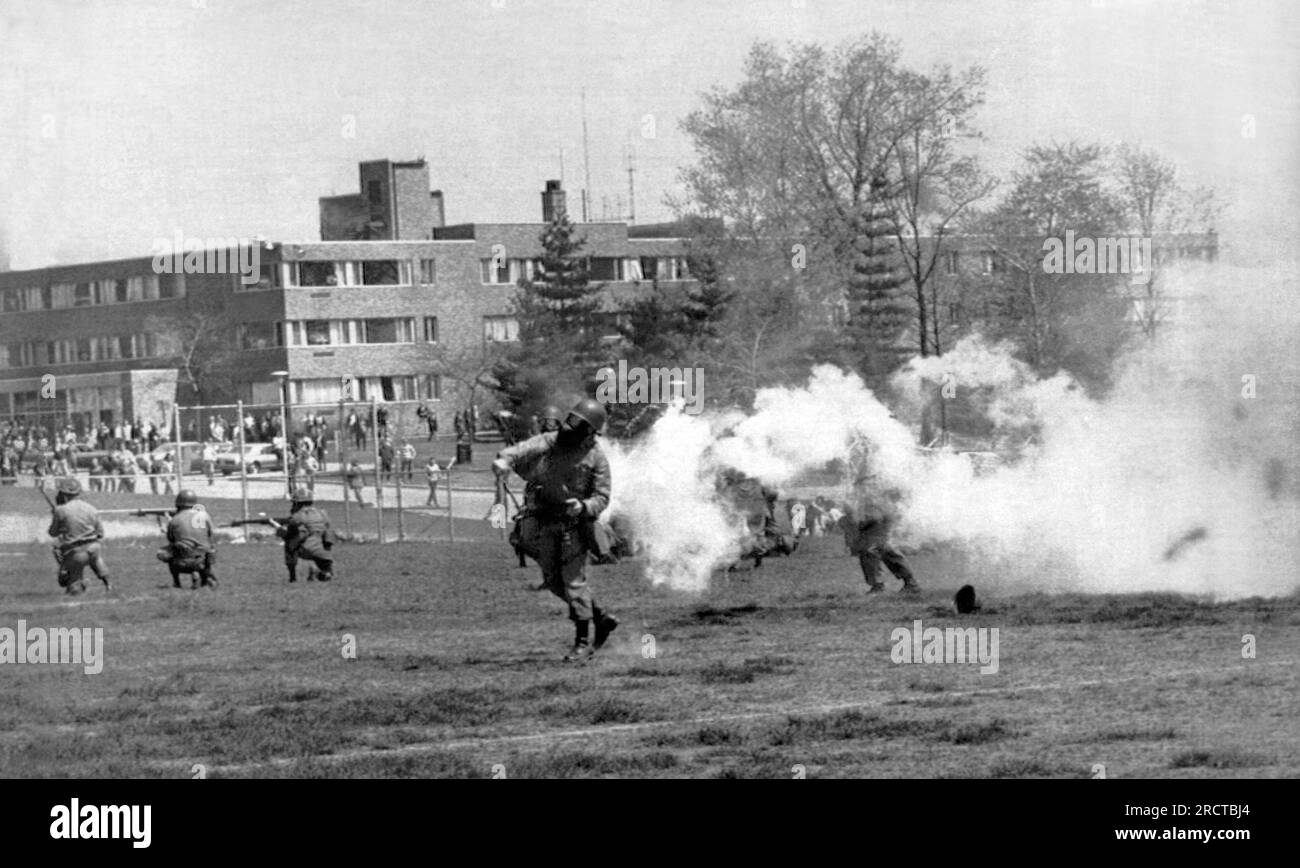 Kent, Ohio:  May 4, 1970. National Guard troops throw tear gas into the rioters at Kent State protesting the American invasion of Cambodia. Shortly after the troops opened fire on the unarmed students, killing four and and wounding nine others. Stock Photo