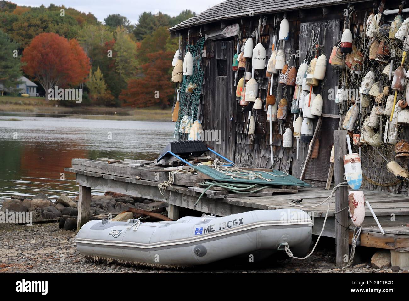 low tide with boat on sand at Cape Neddick Lobster Pound, York, Me and a wall of buoys October 23 2021 Stock Photo