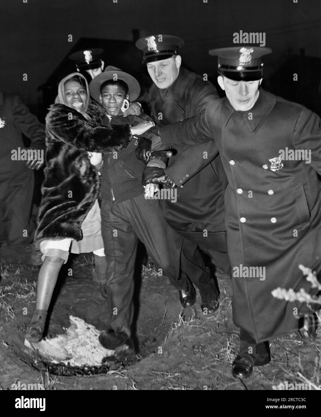 Detroit, Michigan   February 28, 1942 A young black teen, Harold Dillard, 14, is arrested by police during the attempted integration of the Sojourner Truth Housing Project as his sister holds onto him in protest. Stock Photo