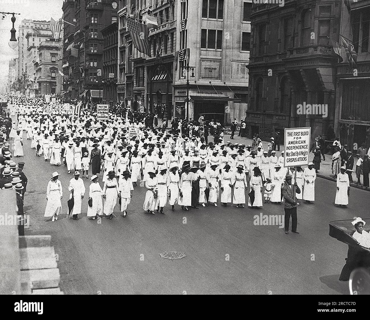 New York, New York: 1917:  A silent march to protest the police’s treatment of blacks during riots in East St. Louis. They marched down Fifth Avenue on that summer Saturday without saying a word. They chanted no chants, sang no protest songs. The only sounds were the disconcertingly mournful thuds of muffled drums — and, of course, the marchers’ footsteps on the hot pavement. It was a “parade of silent protest'. Stock Photo