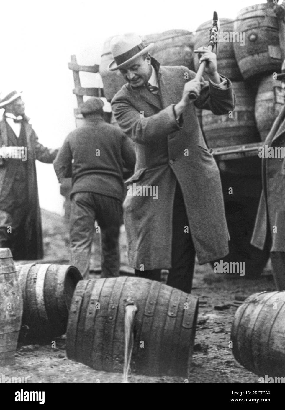 Philadelphia, Pennsylvania:  December, 1924 Public Safety Director Smedley D. 'Duckboards' Butler destroying barrels of beer with a pick axe during Prohibition and letting it run into the  Schuylkill River. Stock Photo