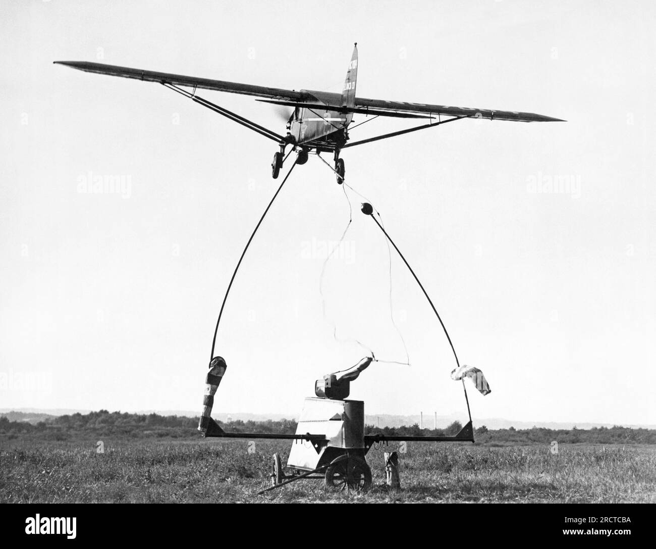 Washington, D.C.:  September 10, 1931 A new airmail pickup device was demonstrated at Washington Hoover Airport today. The airplane has snagged the cord suspended from the two poles on top of the truck and the catapult is projecting the mail bag into the air. Stock Photo