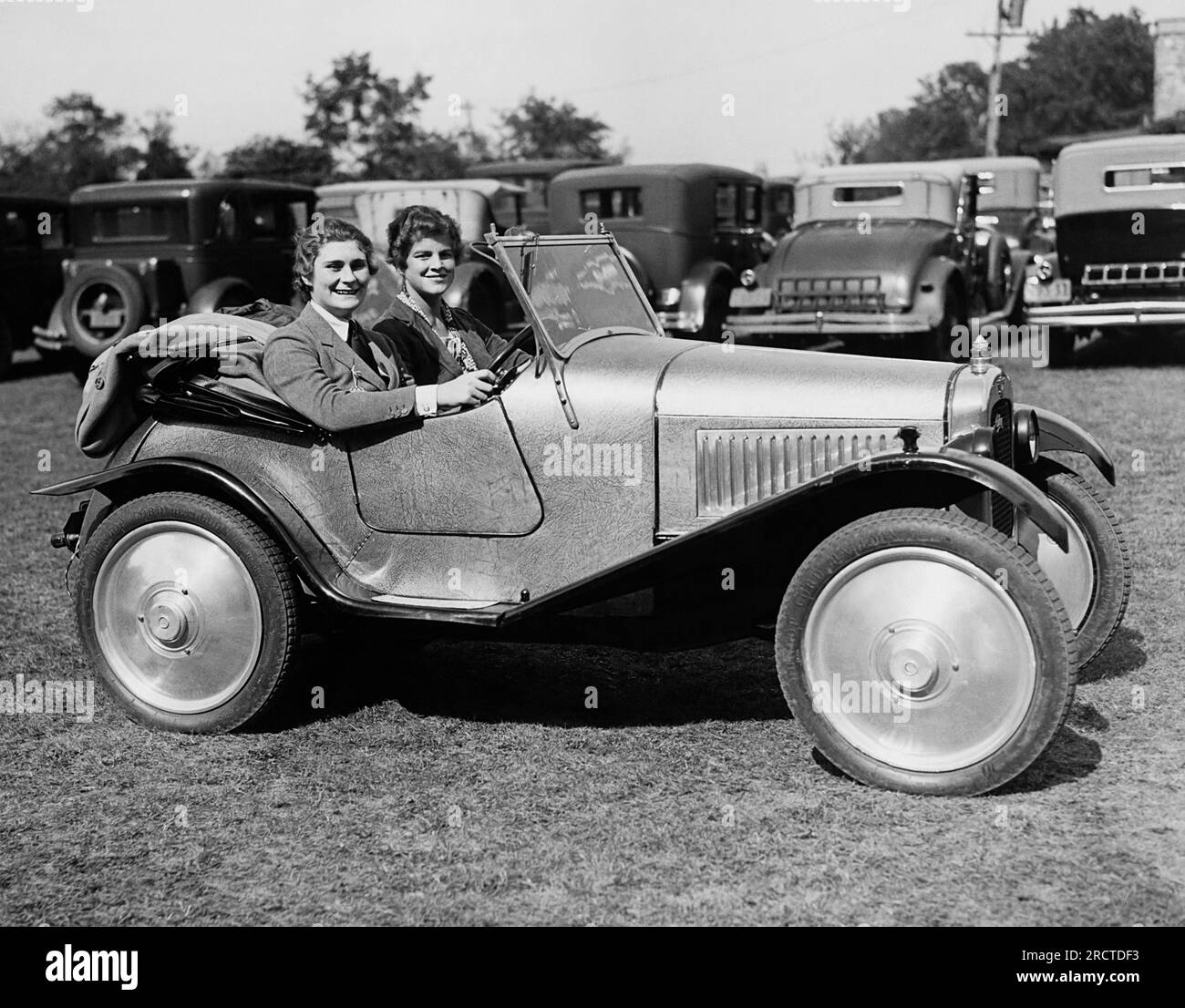 Locust Valley, New York:  c. 1930 New York society women Diana Guest (L) and Anne NIchols arrive in an Austin roadster at the the Piping Rock Club Horse Show. Stock Photo