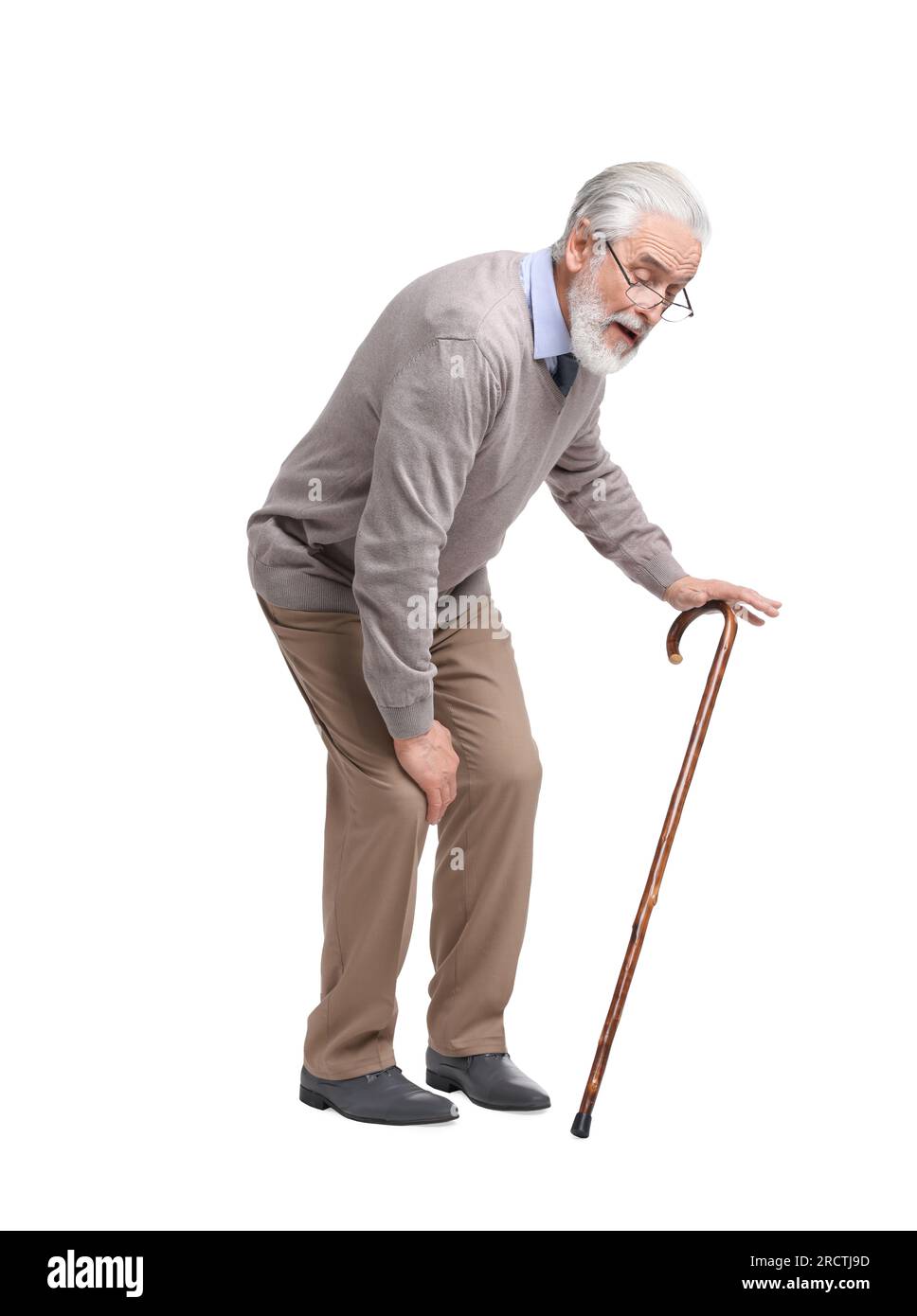 Senior man with walking cane suffering from knee pain on white