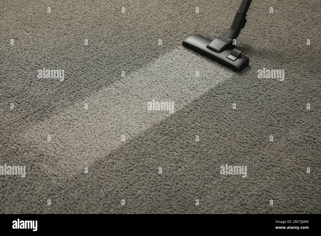 Vacuuming grey carpet. Clean area after using device. Space for text Stock Photo
