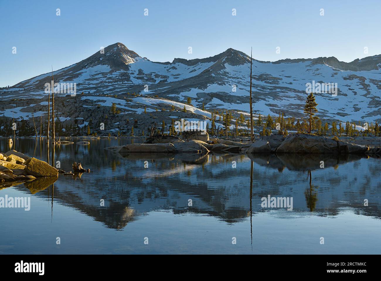Alpine mountains and it's reflections in the lake Stock Photo - Alamy