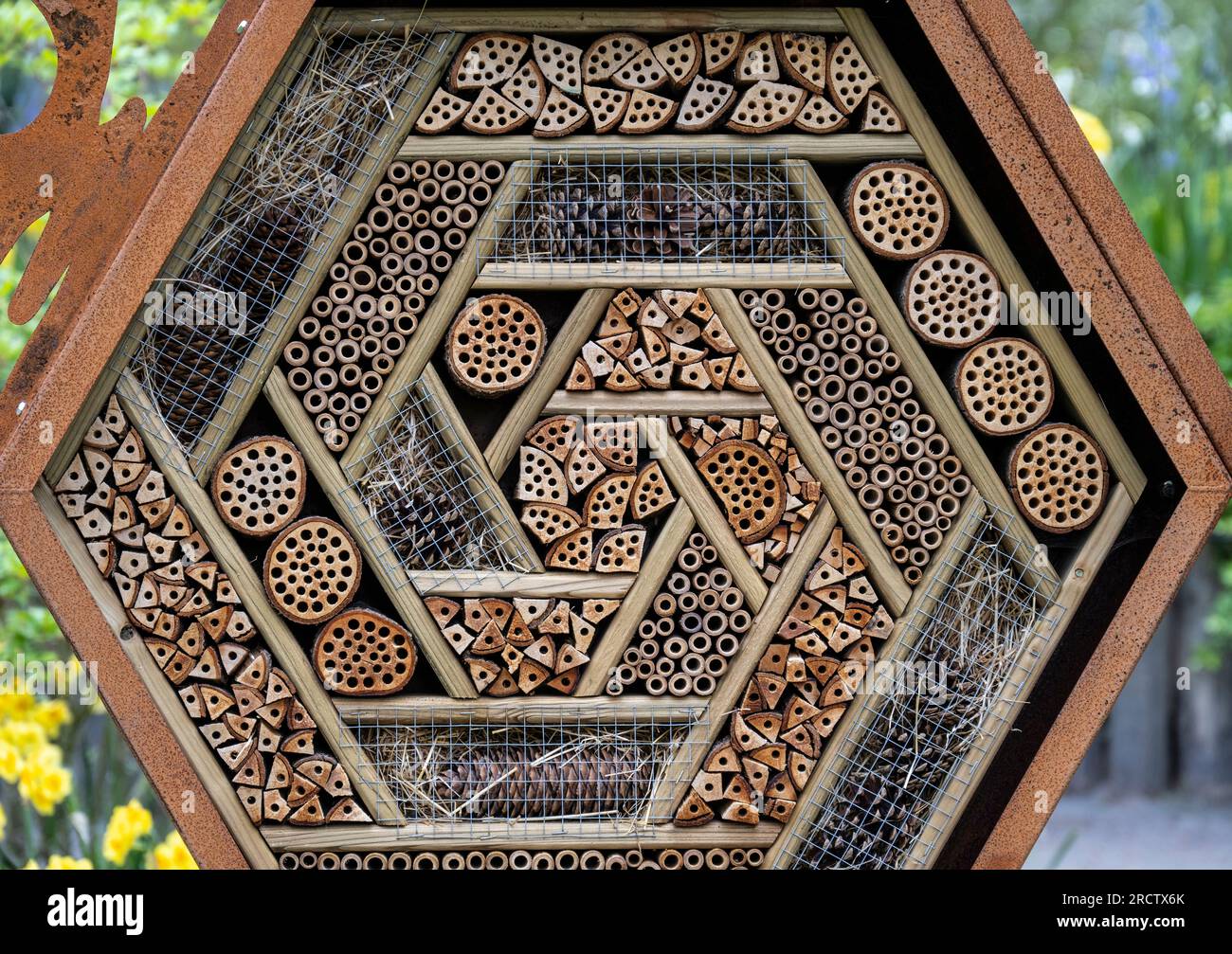 bug motel of insect shelter placed in a garden to attract helpful ...