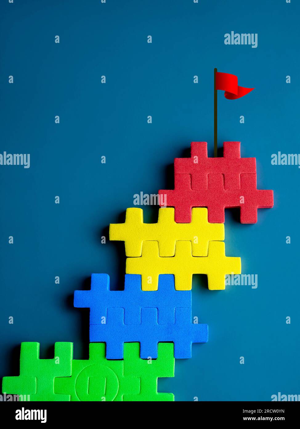 The ultimate goal, red flag on top of colorful puzzle blocks as bar