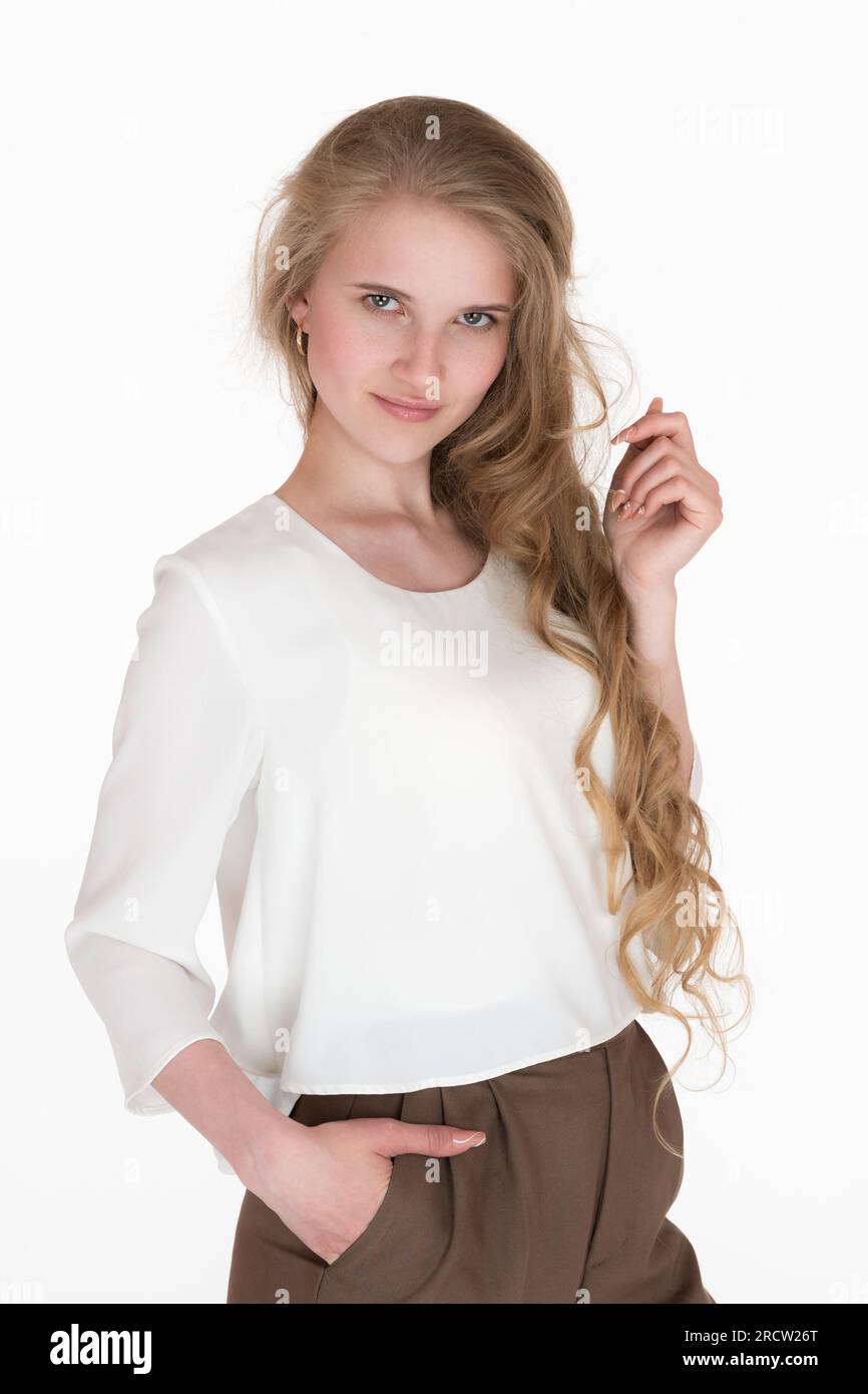 Portrait of charismatic young woman staring at camera. Well-dressed Caucasian blonde female 21 years old with long hair wearing white blouse Stock Photo