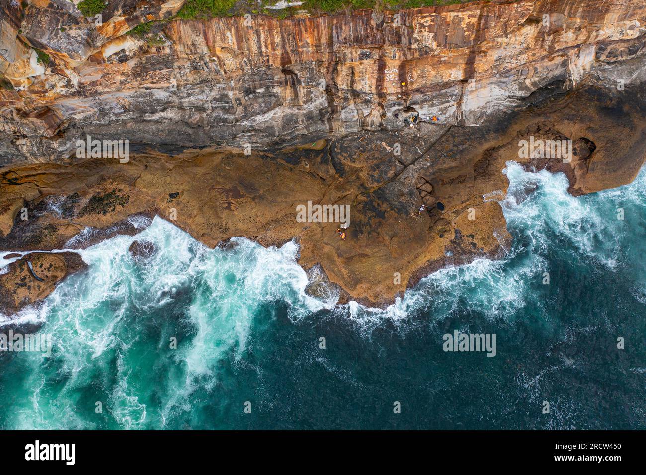 Aerial drone view of people fishing using a fishing rods while standing on rocks, Sudney NSW Australia Stock Photo