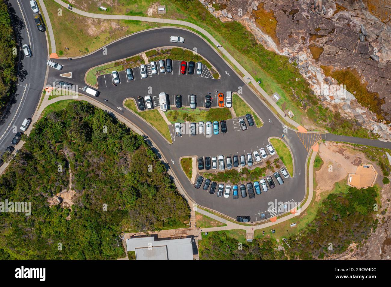Aerial top down view of a coastal parking lot with many cars and