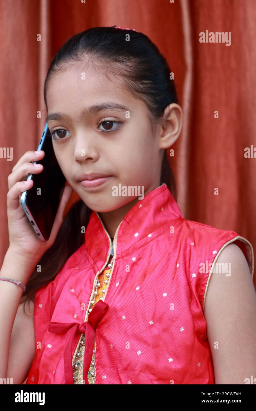 An Indian little pretty girl talking on a mobile phone in various poses