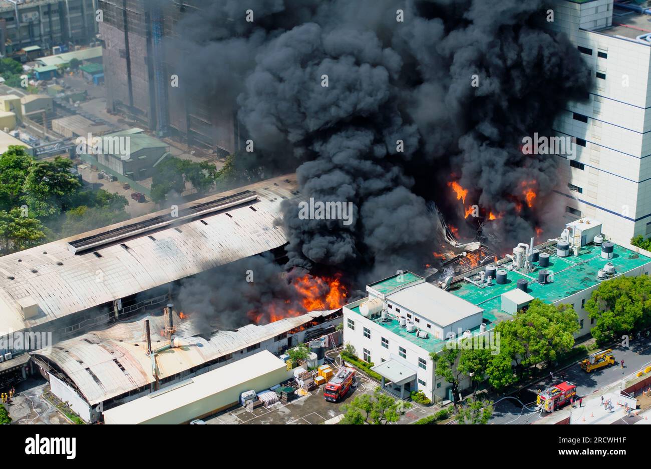 Aerial view of Fire in industrial building. Multi-storey concrete hangar with flames. Factory emergency concept. Stock Photo