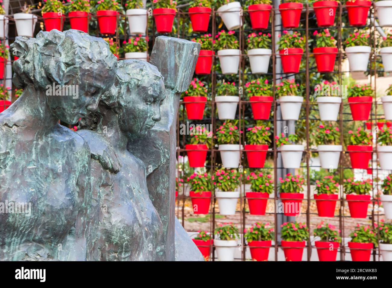 Sculpture in front of red flower pots in Murcia, Spain Stock Photo