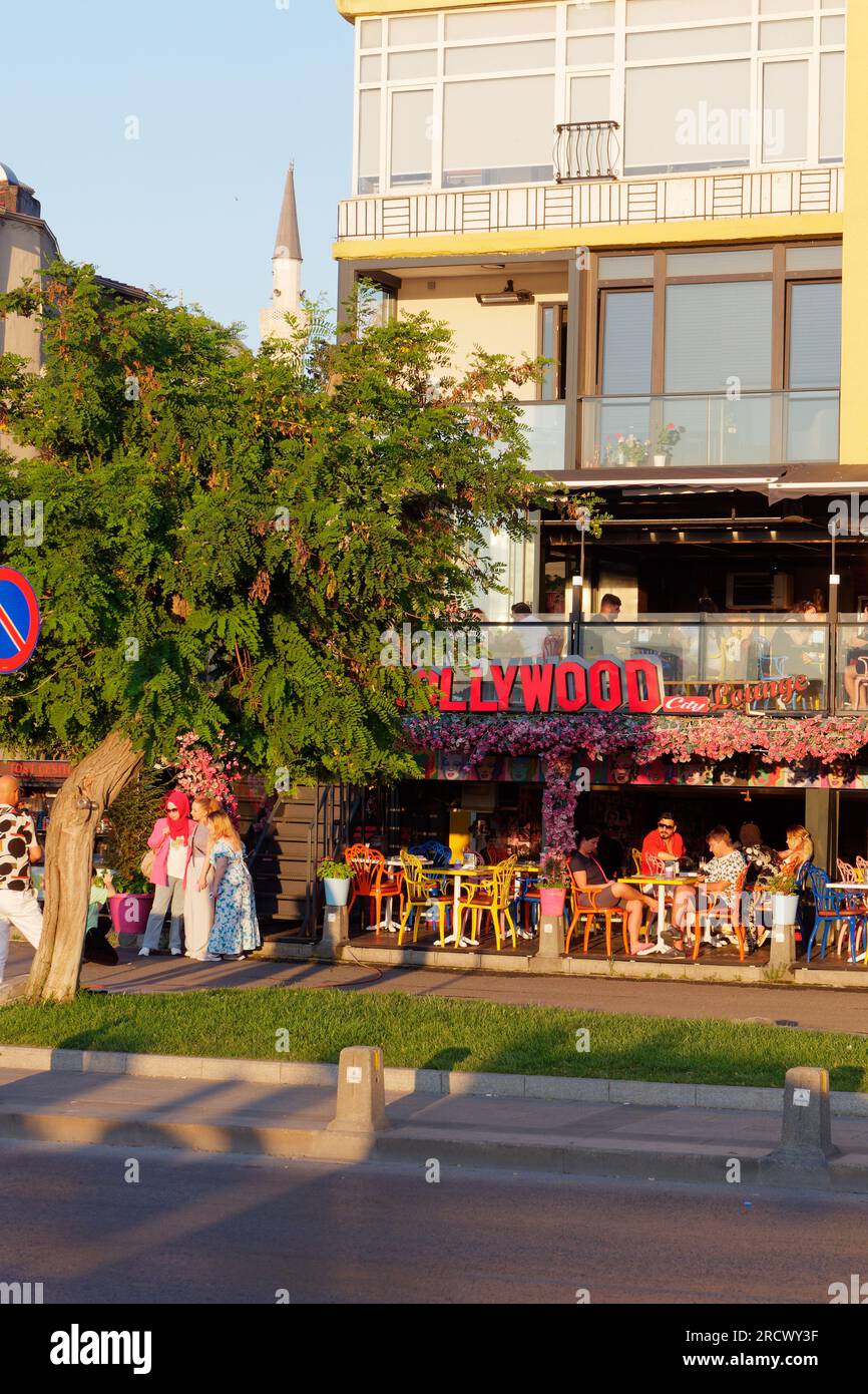 Summers evening in Uskudar, Istanbul. People sit at a colourful restaurant with and a group of women pose for a photo beside some steps. Turkey Stock Photo
