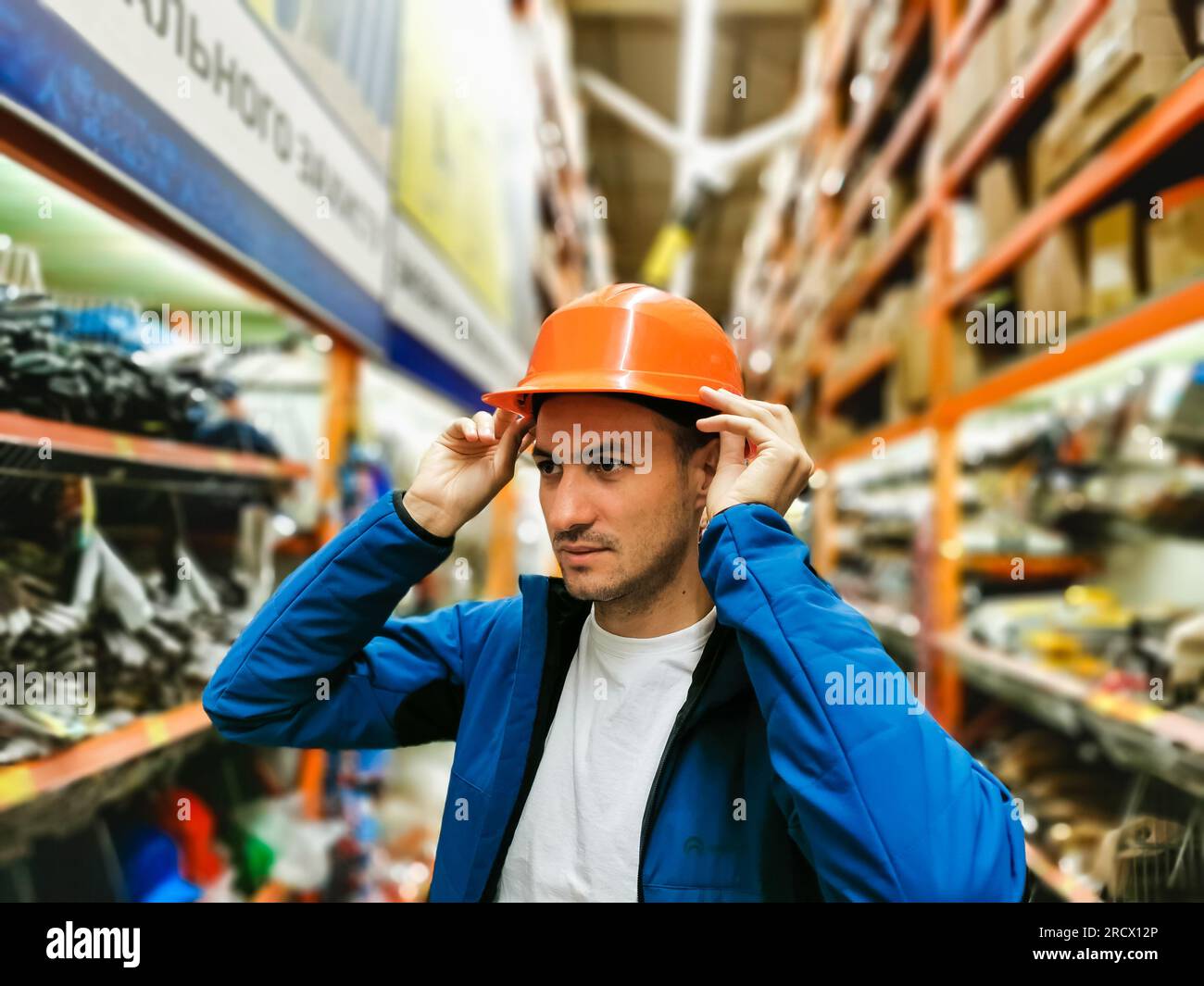 a man measures a helmet in a store Stock Photo