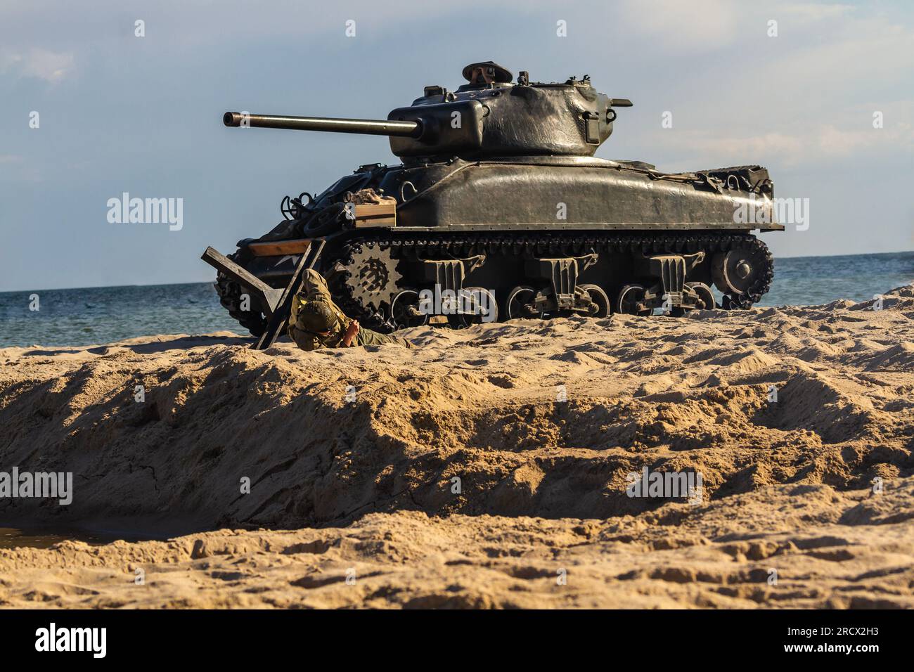 An American World War II Sherman tank on the beach. Tank and soldier in the field of battle Stock Photo