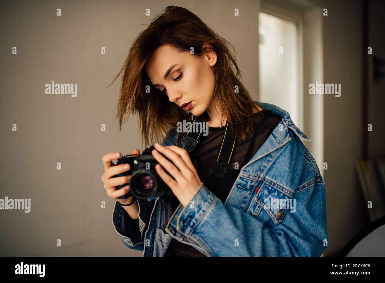 Youg female photographer holding camera. Stock Photo