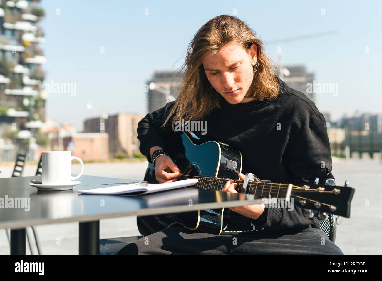 man playing the guitar and studing music composition Stock Photo