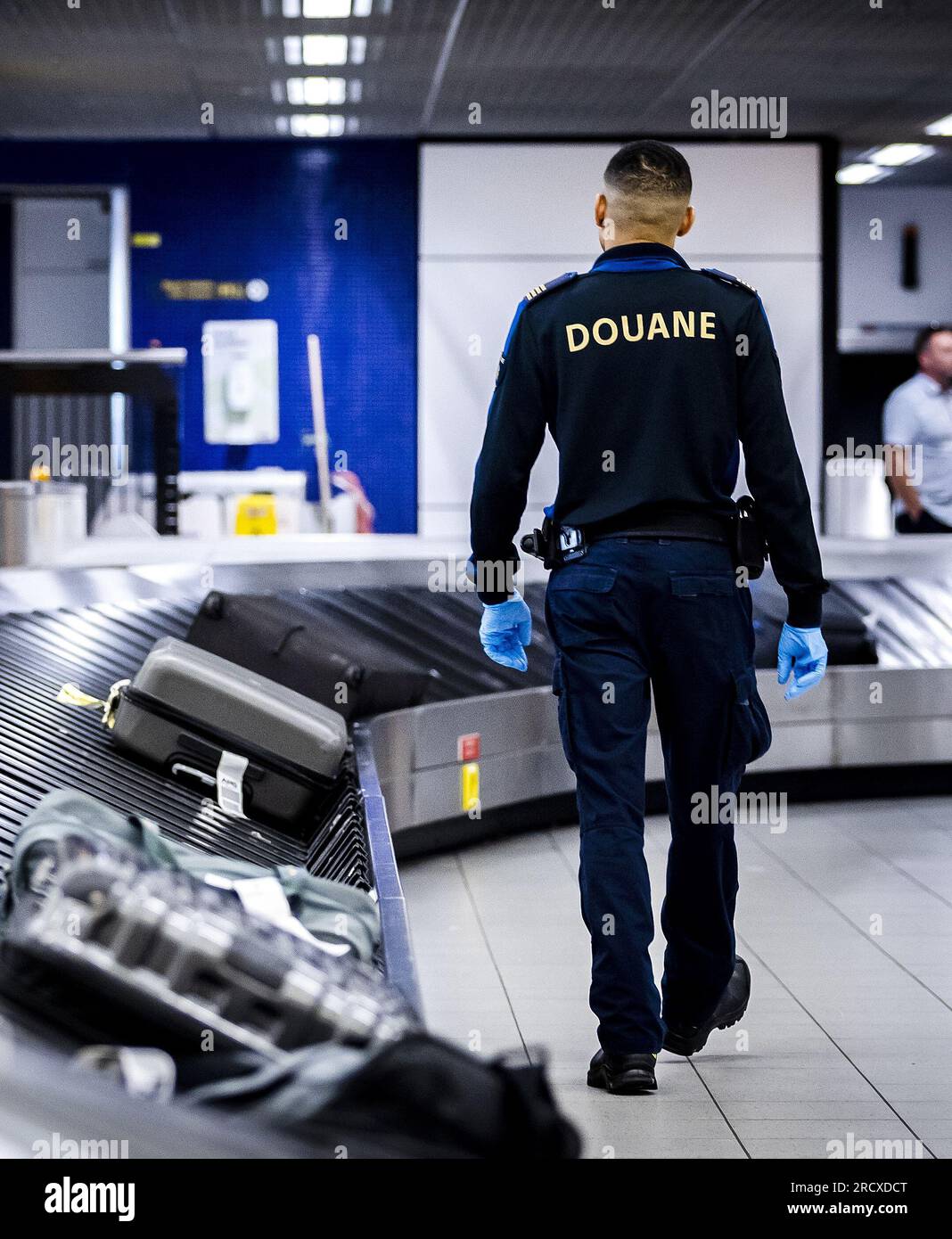 SCHIPHOL - A customs officer inspects a suitcase at Schiphol Airport. ANP  REMKO DE WAAL netherlands out - belgium out Stock Photo - Alamy